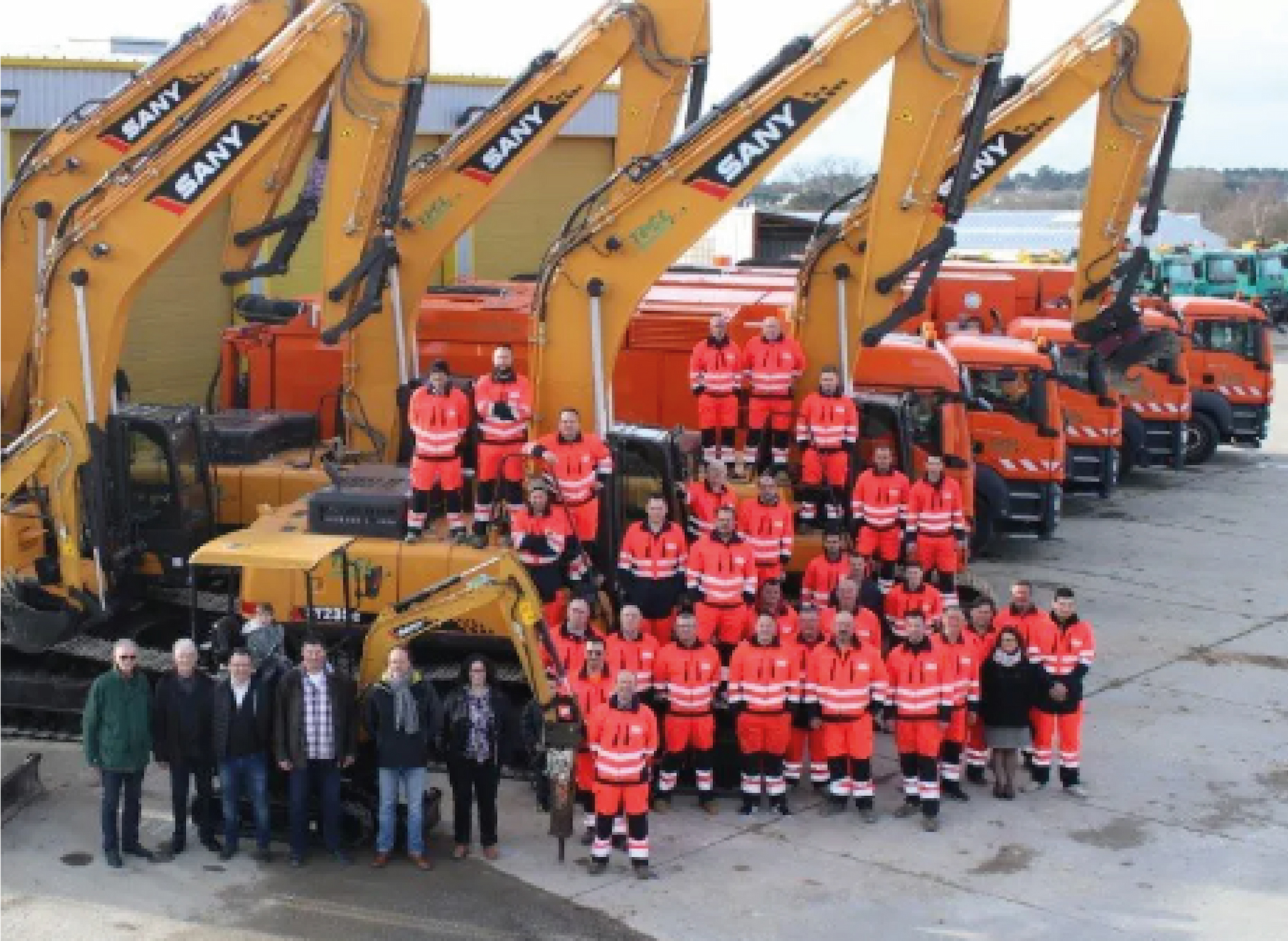 Photo d'équipe devant le matériel de travaux public