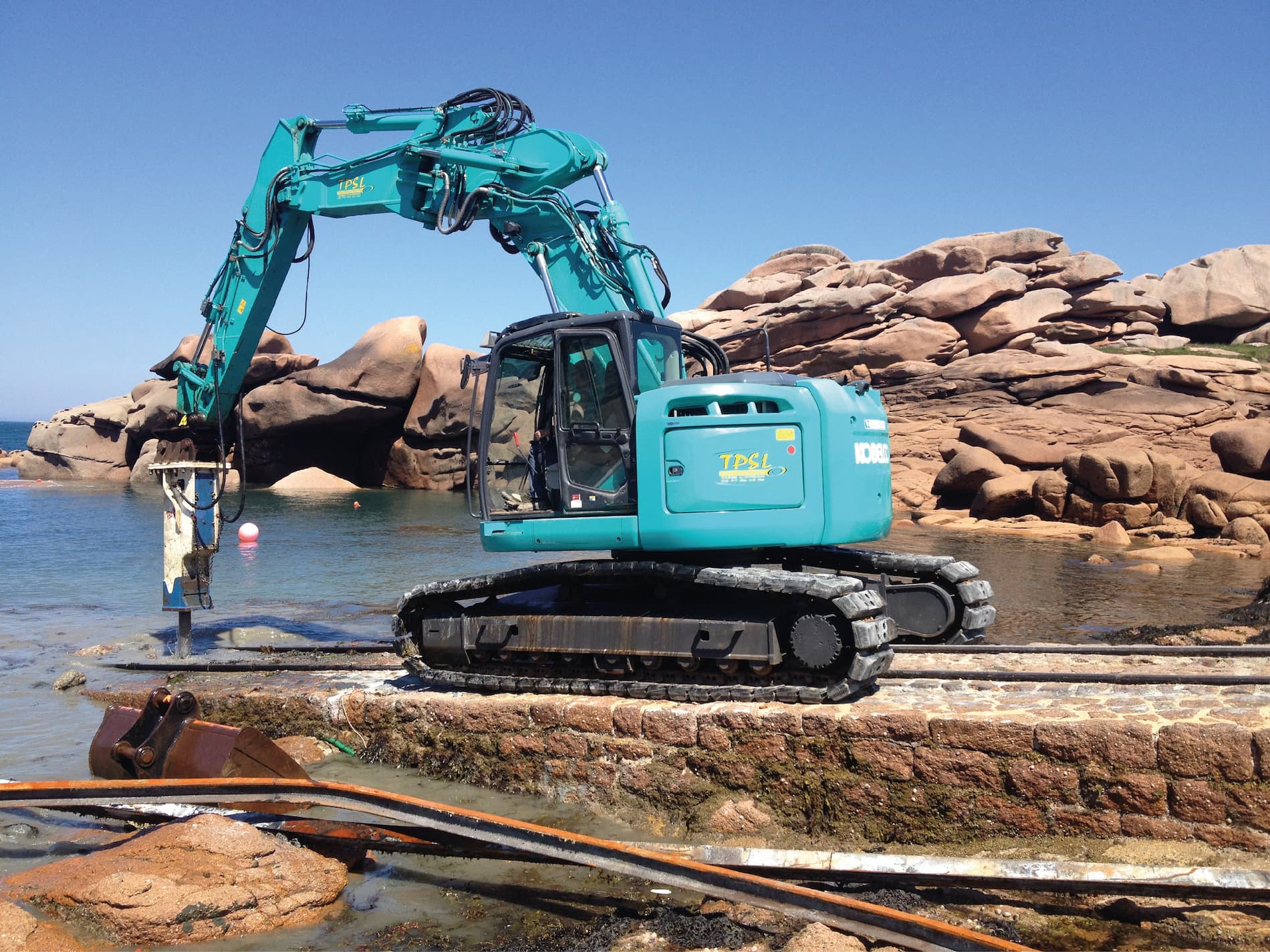 Pelleteuse bleue chantier en bord de mer