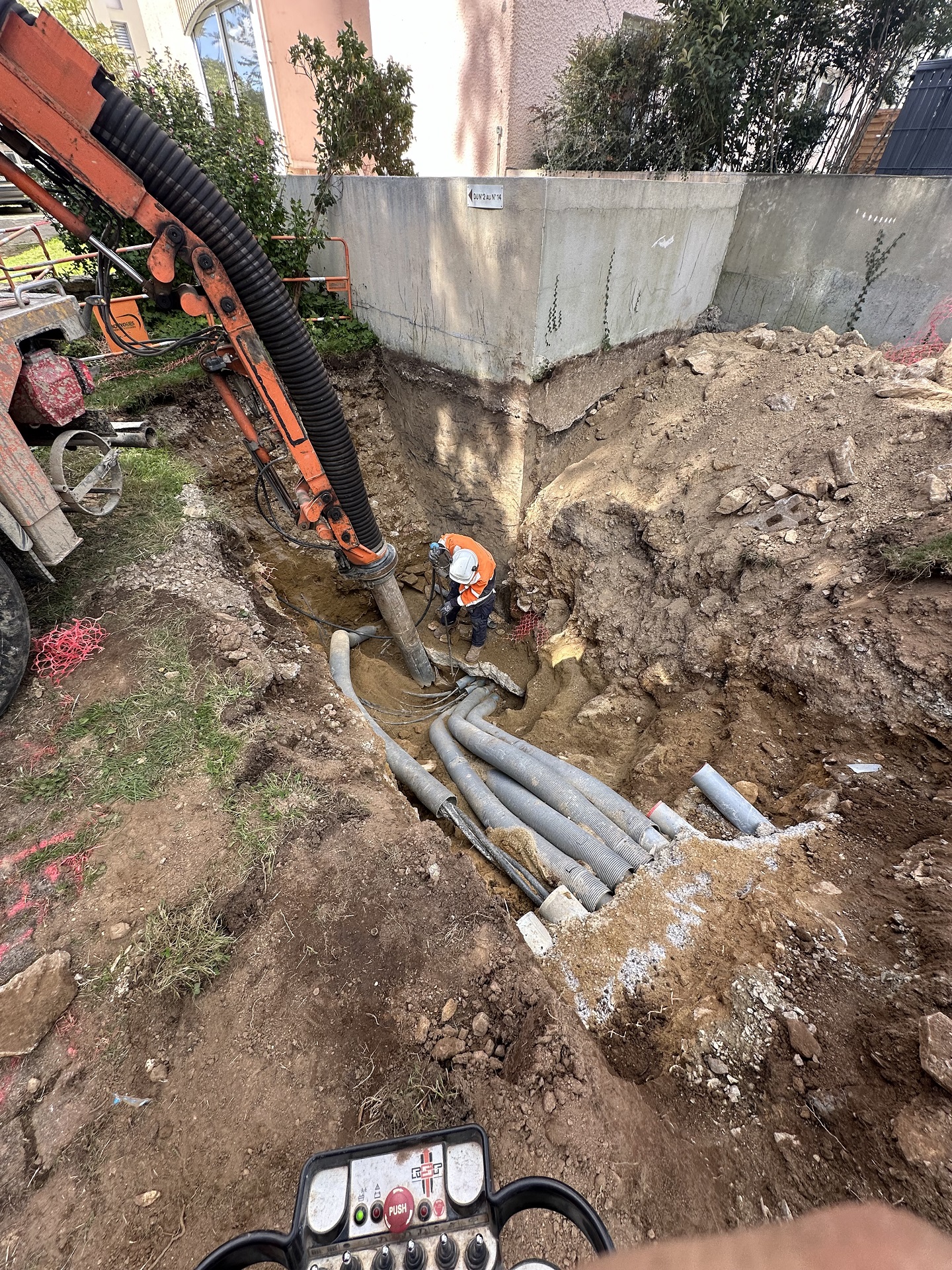 Travaux par aspiration sur réseau électrique HTA. Le suiveur utilise la pioche à air pour dégager le dessous du réseau inaccessible avec l'embout en douceur.