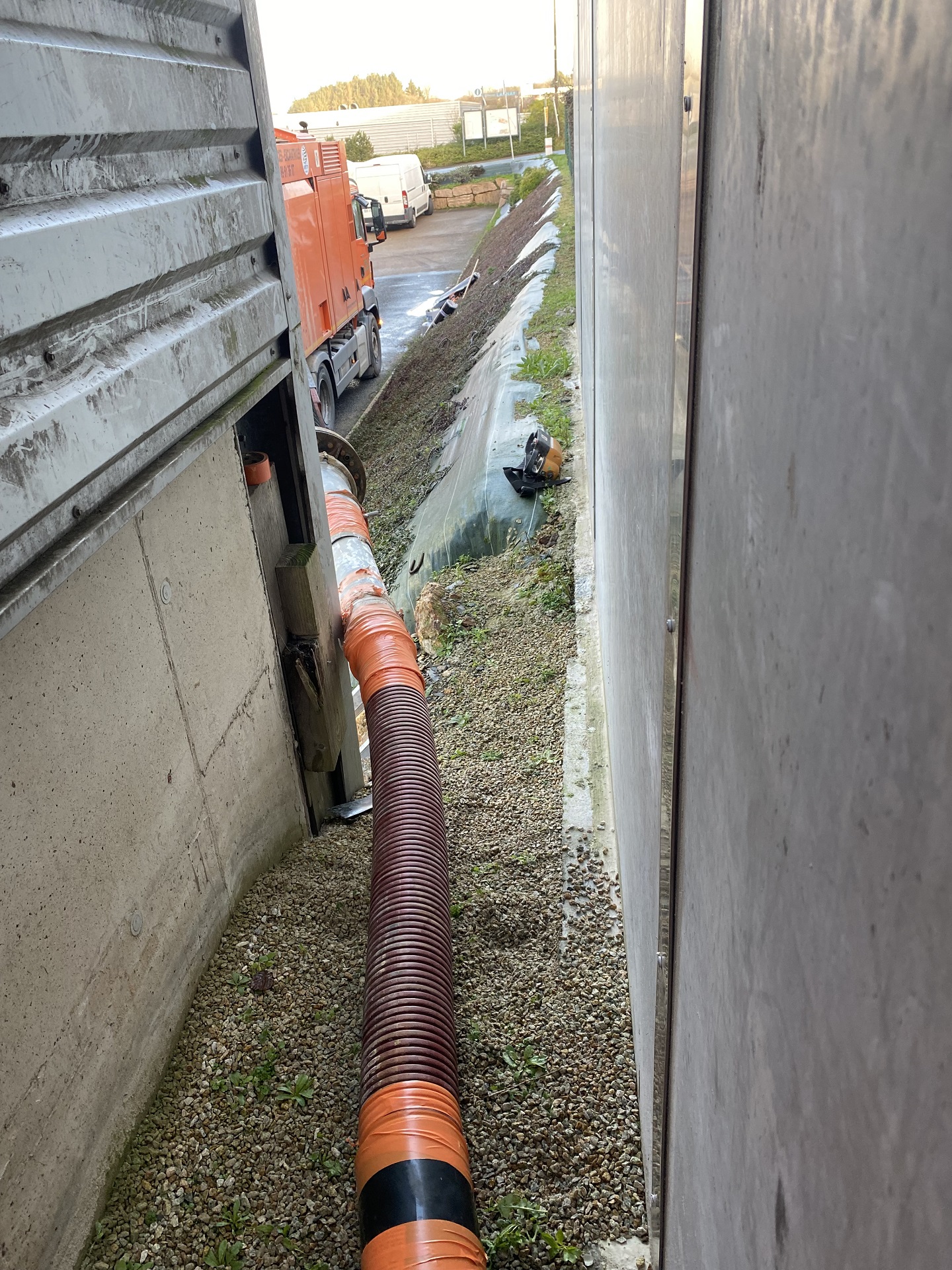 Accéder à un espace exigu dans un bâtiment industriel en rajoutant une longueur de tuyau à l'embout du bras de l'aspiratrice.